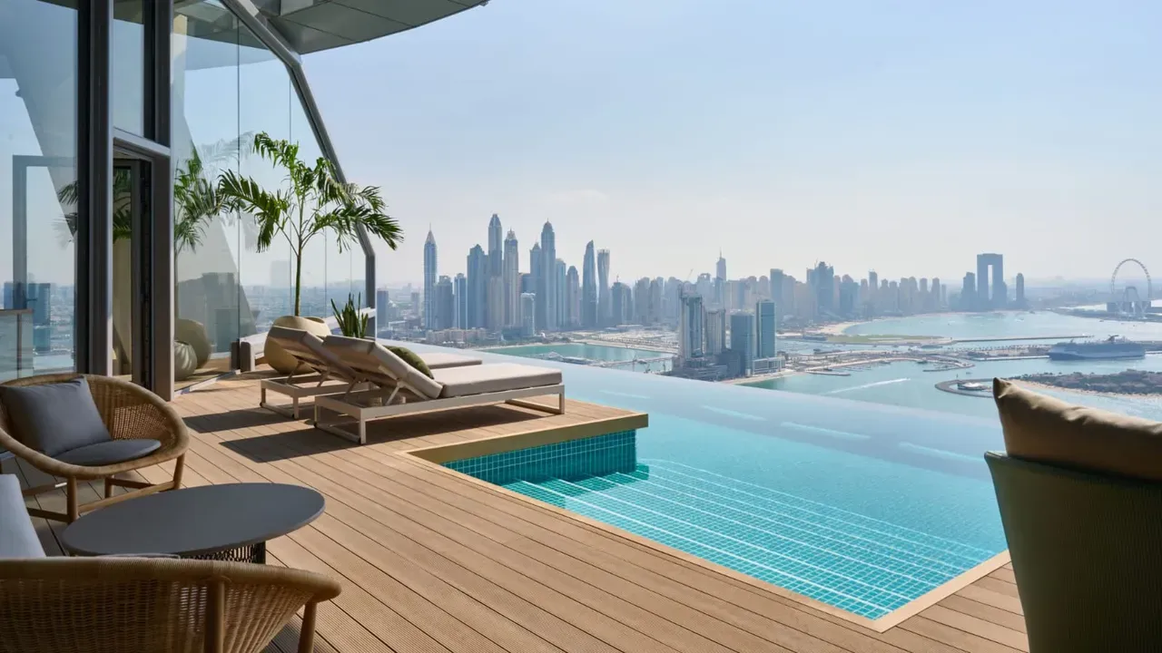 Taras z basenem typu infinity i leżakami — panoramiczny widok na skyline Dubaju i wybrzeże