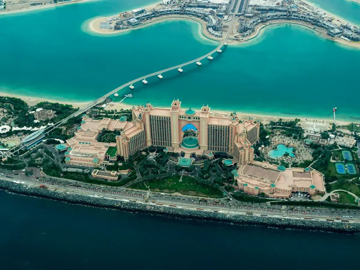 Zdjęcie lotnicze przedstawiające kompleks hotelowy Atlantis The Palm na tle turkusowej wody i piaszczystej plaży